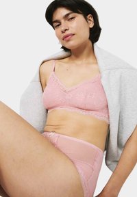 Pink lace bralette with floral patterns and adjustable straps, paired with matching high-waisted panties featuring mesh accents and bow detailing.