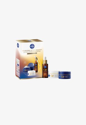 NIVEA Q10 skincare gift set featuring two cream jars (white and blue) and a brown serum bottle, presented in a gold and blue box.