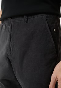 Ciemnoszare spodnie sztruksowe o fakturowanej powierzchni, z zapięciem na guzik, kieszeniami bocznymi oraz elastycznym pasem dla komfortu.