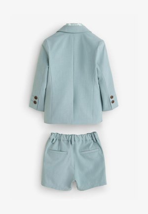 Világoskék, két gombos, testre szabott blézer, hozzáillő, gumis derekú és oldalsó zsebekkel ellátott sorttal. Az anyag sima tapintású.