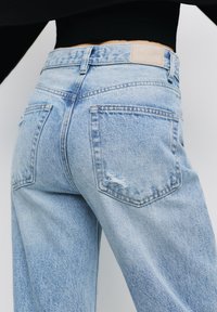 Jeans in denim azzurro chiaro con una vestibilità rilassata, dotati di due tasche posteriori e sottili dettagli sdruciti. Etichetta sul girovita.