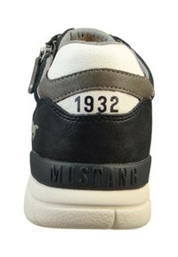 Černé a šedé kožené tenisky s bílými akcenty, s číslem "1932" embosovaným na patě a "MUSTANG" na podrážce.