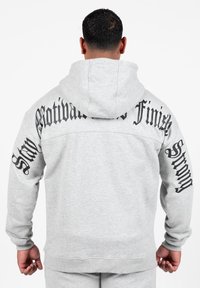 Grijze hoodie met een groot, zwart tekstontwerp op de achterkant en mouwen. De stof lijkt zacht en heeft een klassieke pasvorm met een capuchon.