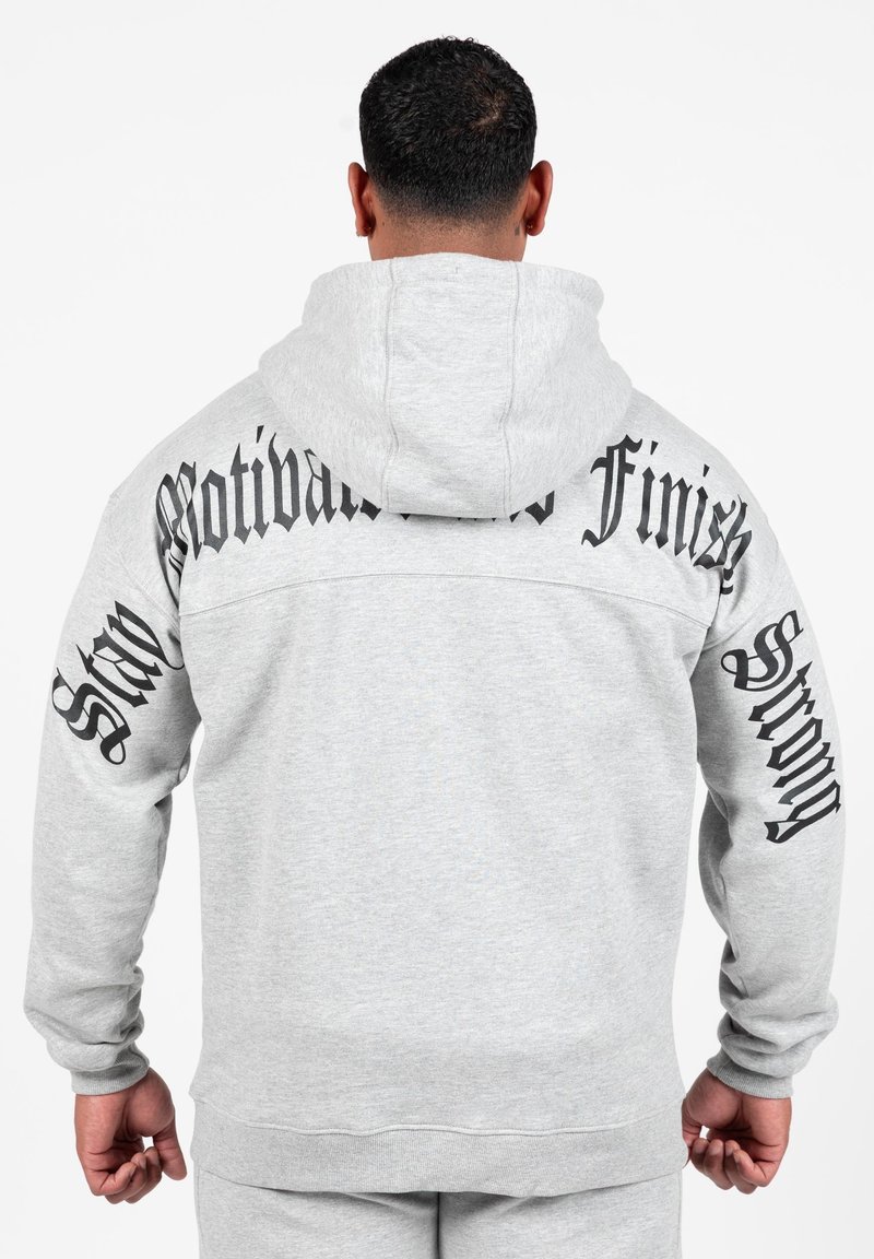 Grijze hoodie met een groot, zwart tekstontwerp op de achterkant en mouwen. De stof lijkt zacht en heeft een klassieke pasvorm met een capuchon.