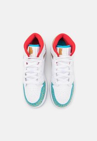 Bílé tenisky s červenými a tyrkysovými akcenty. Mají strukturovaný tyrkysový design na podešvi a vzorové prvky poblíž špičky.