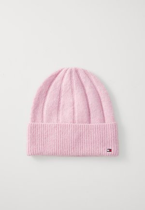 Pink knitted beanie with ribbed texture, featuring a folded cuff and a small logo tag on the side. Soft, cozy material.