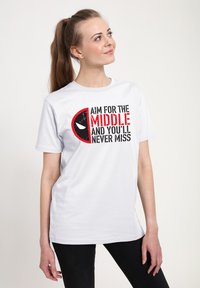 Hvid bomulds T-shirt med iøjnefaldende sort og rød grafisk tekst: "SIGT MOD MIDTEN, OG DU VIL ALDRIG MISSER" med et logo design.