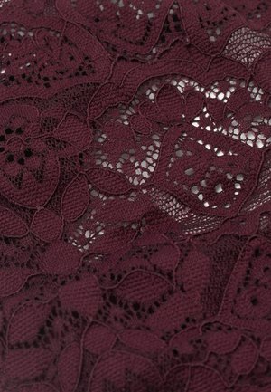 Vinrött spetsmaterial med blommönster och intrikata detaljer. Har en fin textur och detaljer med öppet vävda partier.