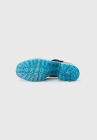 Semelle de chaussure transparente avec une couleur bleue vibrante et des paillettes, un motif texturé et des rainures pour l'adhérence. Design supérieur simple en noir.