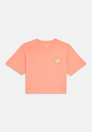 Kortærmet, cropped t-shirt i koralstof med et gyldent glitterhjerte og solstråledesign på venstre bryst. Blød tekstur.