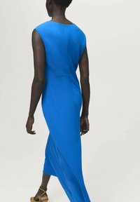 Vestido largo y ajustado de tela azul brillante, con escote barco, mangas cortas y una sutil abertura en la parte posterior. Textura suave en toda su extensión.