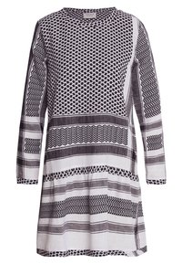 Vestido de manga larga en blanco y negro con patrones geométricos, cuello redondo y un corte holgado con textura fruncida en el dobladillo.