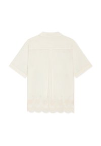 Chemise crème à manches courtes avec col, couture droite dans le dos et ourlet festonné avec petite broderie florale.