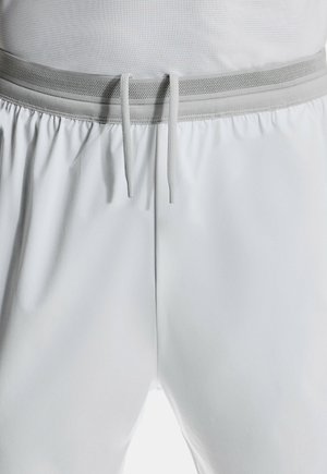 Vita atletiska shorts i lättviktsmaterial med elastisk linning som har grå nätaccentuer och dragsnören. Slät textur.