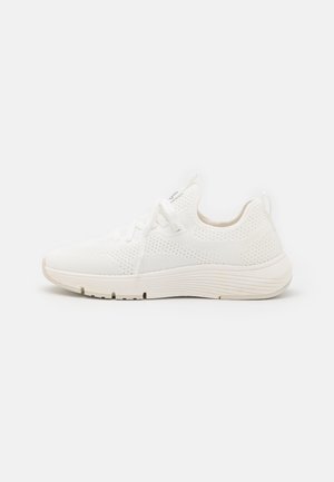 Biały dziergany sportowy sneaker z przodem na sznurowadła i grubą podeszwą, pokazany z boku na jednolitym białym tle.