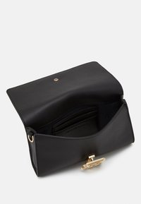Musta nahkainen käsilaukku, jossa on läppäkiinnitys, kultaiset metalliosat ja sisäpuolella korttipaikat sekä logo. Sileä pinta, minimalistinen muotoilu.