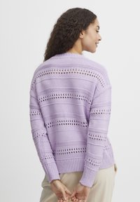 Lila pletena jopica z vodoravnimi in navpičnimi odprtimi vzorci, rebrastimi manšetami in sproščenim krojem.