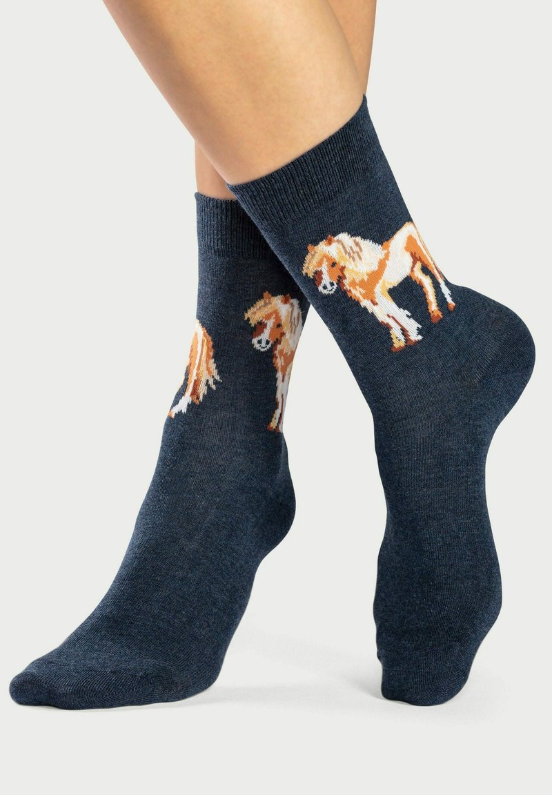 Marinefarbene Knöchelsocken mit gestrickter Textur zeigen auf jeder Seite orangefarbene und weiße Pferdemuster. Die gerippten Bündchen sorgen für einen enganliegenden Sitz.