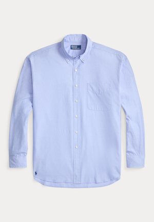 Lys blå langermet skjorte med knapper, krage, enkelt brystlomme og en liten brodert logo på nedre venstre kant.