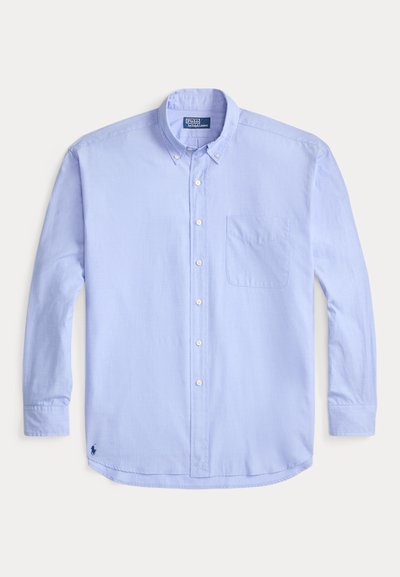 Ανοιχτό μπλε πουκάμισο με μακριά μανίκια, κουμπιά, γιακά, μία τσέπη στο στήθος και μικρό κεντητό λογότυπο στο κάτω αριστερό μέρος.