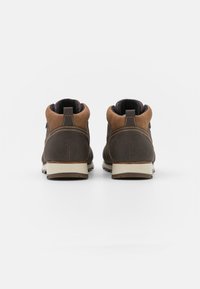 Brown leather ankle boots with textured sides, cream rubber outsole, and contrasting stitching. Features padded collar and pull tab.