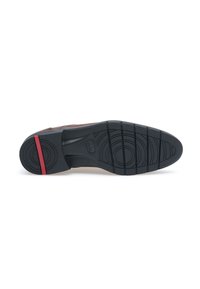Suola di scarpe in gomma nera caratterizzata da scanalature orizzontali, un motivo di grip testurizzato e una striscia rossa vicino al tallone.
