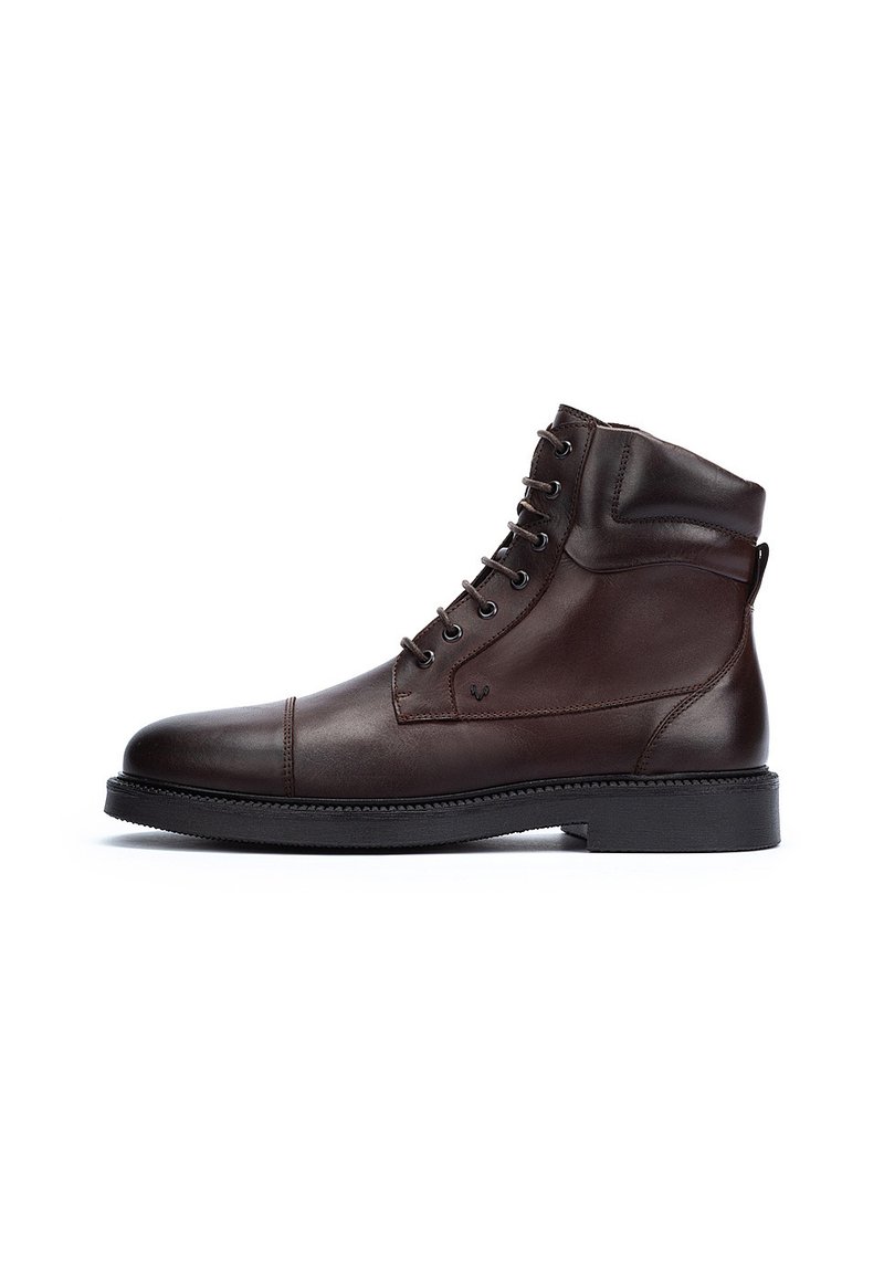 Botas de tobillo de cuero marrón con un acabado suave, punta redonda, cordones en la parte frontal y una suela de goma texturizada y baja. Cuenta con una lengüeta en la parte trasera.