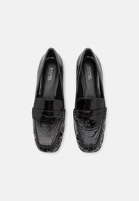 Zwarte lakleren loafers met een gestructureerde afwerking, met een gestikte detail rond de teen en een platte, gladde zool.