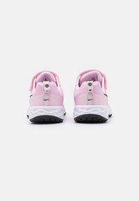 Scarpe da atletica rosa con tomaia in rete, collare imbottito, suole bianche e suola nera antiscivolo. Presentano una fascia e un logo sul tallone.