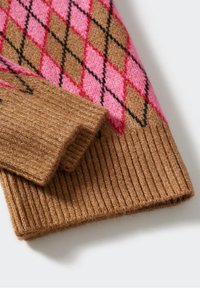 Gros plan d'une manche de pull en tricot pliée avec un bord-côtes marron et un motif losanges rose et marron.
