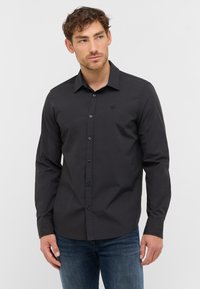 Zwarte langemouwen shirt van katoen met een button-down kraag en een subtiele logo op de borst, gecombineerd met blauwe jeans.