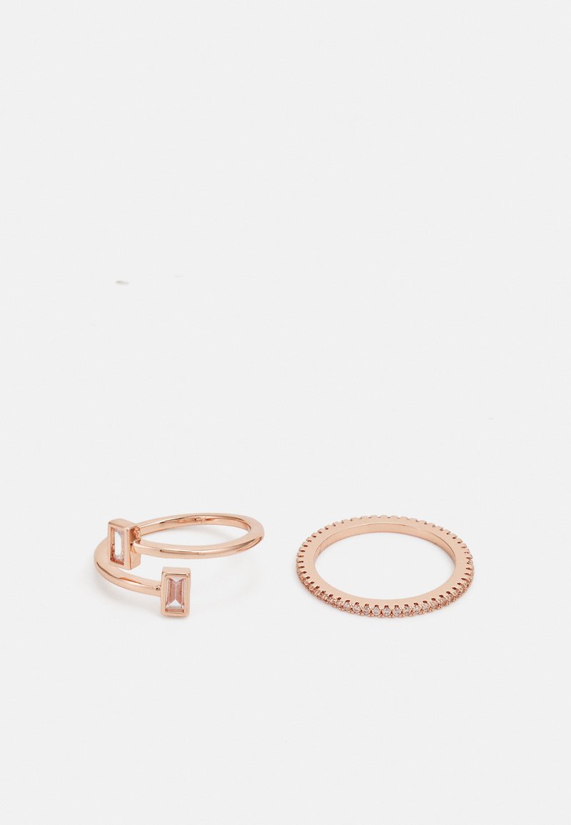 Le fedi in oro rosa presentano un design a doppio band con pietre rettangolari e una fascia circolare con un bordo texturizzato. Finitura liscia e lucida.