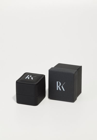 Black jewelry box with a textured finish, featuring a padded lid and silver logo. A second square box in similar black material is beside it.