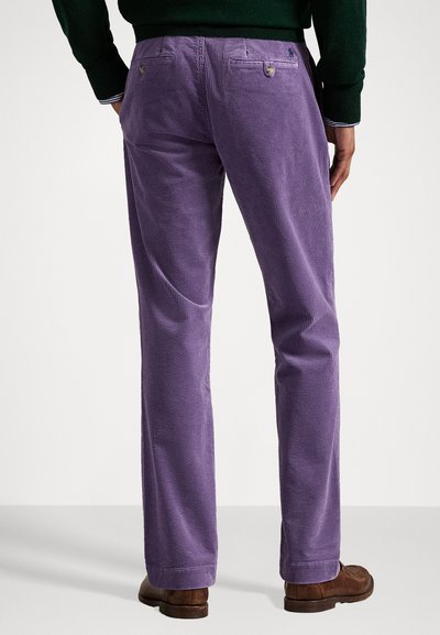 Paarse corduroy broek met een rechte pijp, voorzien van achterzakken en subtiele textuur. G gedragen met een donkergroene trui en brown schoenen.