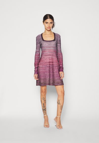 Φόρεμα με μακριά μανίκια που διαθέτει gradient σχέδιο σε αποχρώσεις μωβ και ροζ, με τετράγωνη λαιμόκοψη και υφή υφάσματος. Η τελείωση φτάνει λίγο πάνω από το γόνατο.