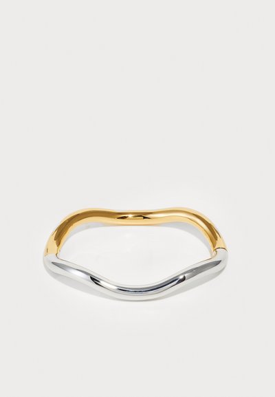 Brăţară din metal în două tonuri cu un design neted, ondulant, având secţiuni strălucitoare de aur şi argint, evidenţiind o tranziţie fără cusur între culori.