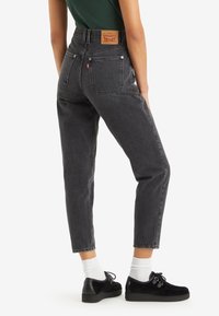 Högmidjade svarta denimjeans har raka ben, klassisk femfickdesign och ett märkesläderpatch på baksidan av midjan.