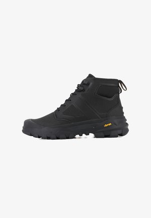 Stivale nero di media altezza con tomaia sintetica, suola robusta, design angolare, dettagli testurizzati e logo Vibram giallo sulla suola.