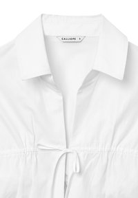 Camicia bianca con dettaglio a coulisse, caratterizzata da una texture liscia e una vita espandibile. L'etichetta riporta "CALLIOPE" con taglia "S".