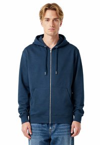 Felpa con zip di un blu navy realizzata in un tessuto misto cotone, con tasca frontale, cappuccio con cordino e polsini a costine. Texture morbida in evidenza.