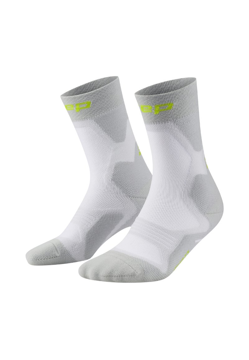 Calze sportive bianche e grigio chiaro, con un design a maglia testurizzata, punta rinforzata e dettagli con logo verde neon vicino al risvolto.
