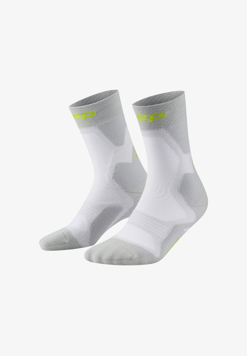 Calze sportive bianche e grigio chiaro, con un design a maglia testurizzata, punta rinforzata e dettagli con logo verde neon vicino al risvolto.