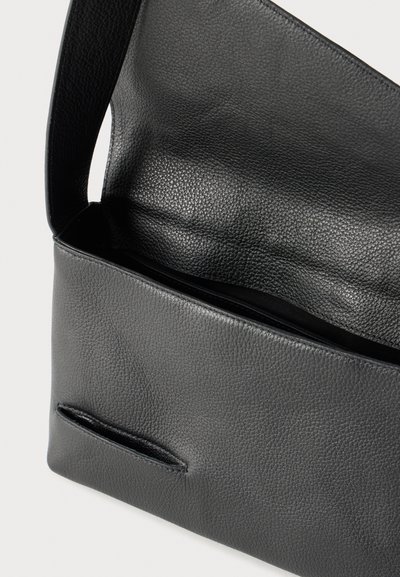 Geantă de umăr din piele texturată neagră, cu clapetă deschisă în partea de sus și captuseală interioară vizibilă, pe fundal alb.