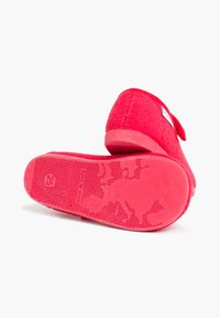 Zapatillas de fieltro rojas con suela de goma texturizada, con forma redonda y un pequeño lazo decorativo en un lado. Talla marcada como 25.
