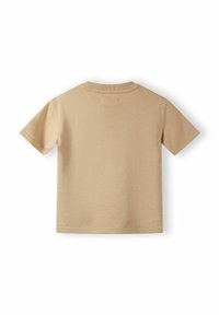 Beige pamut póló rövid ujjakkal, kerek nyakkivágással és minimális varrásokkal. Simaság jellemzi, egyszínű, további részletek nélkül.