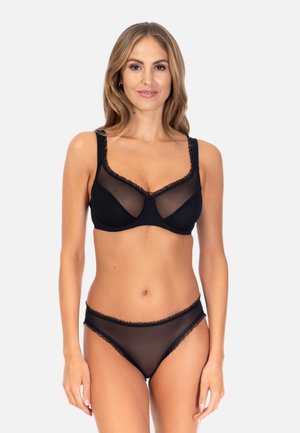 Black lingerie set featuring a sheer bra with ruffled edges and matching low-rise panties, highlighting a smooth, delicate texture.