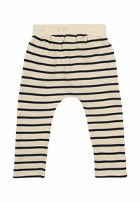 Prúžkové legíny v krémovej a námodrej farbe, s elastickým pásom a voľným strihom. Mäkko bavlnený materiál s hladkou textúrou.