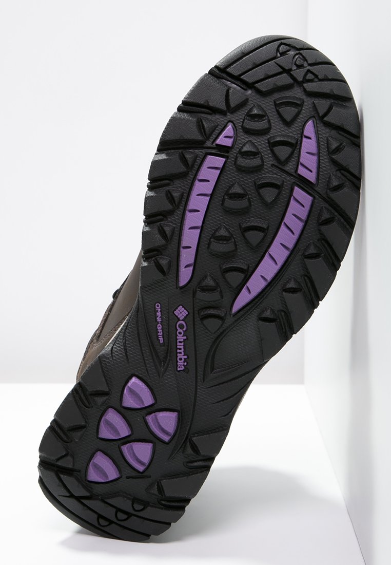 Suola delle calzature Columbia, gomma nera con accenti viola. Presenta modelli di battistrada profondi per aderenza e durata. Logo impresso sul lato.