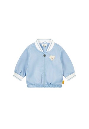 Giacca bomber azzurro chiaro con patch di orso sul petto. Presenta polsini e colletto a coste bianchi e chiusura con zip. Tessuto liscio.