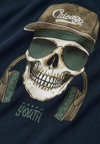 Zwart T-shirt met een grafisch ontwerp van een schedel die een zonnebril en een pet draagt, met een hoofdtelefoon en de tekst "URBAN YOUTH" eronder.